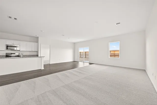 a view of empty room with kitchen