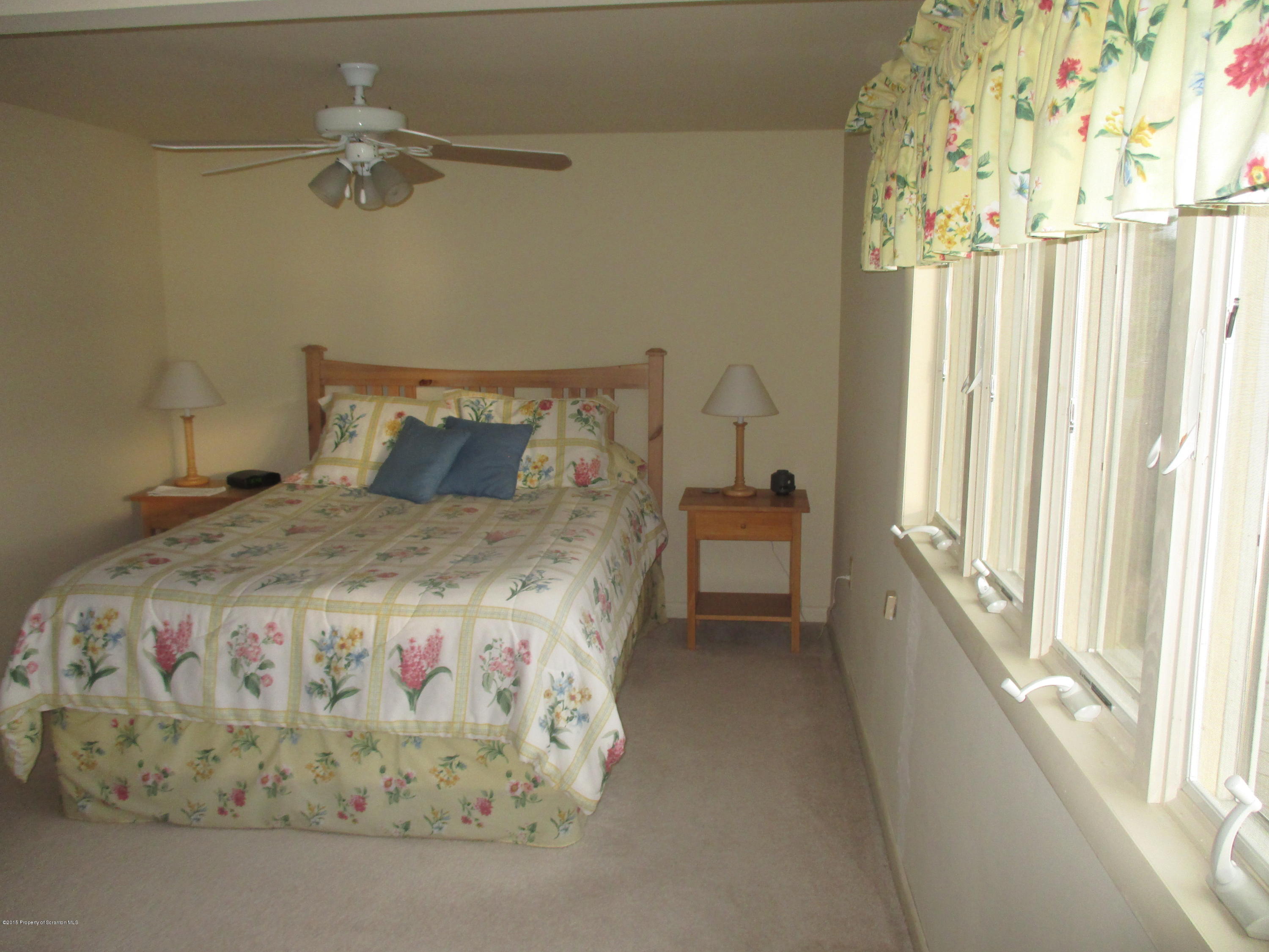394 Point Road Lake Winola, PA 18419 - Photo 18 of 28 a spacious bedroom with a bed and a chandelier