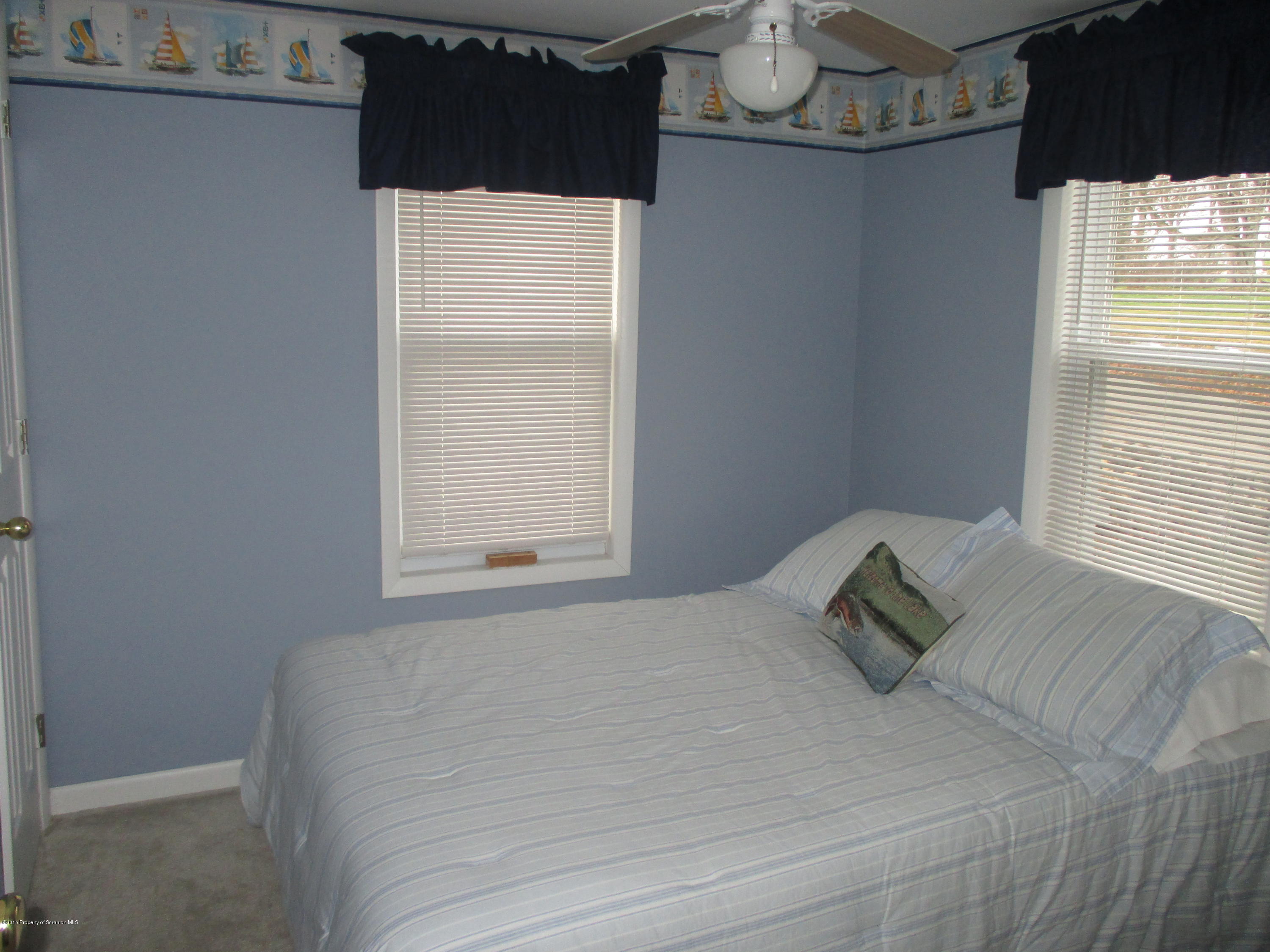 394 Point Road Lake Winola, PA 18419 - Photo 20 of 28 a bed sitting in a bedroom next to a window