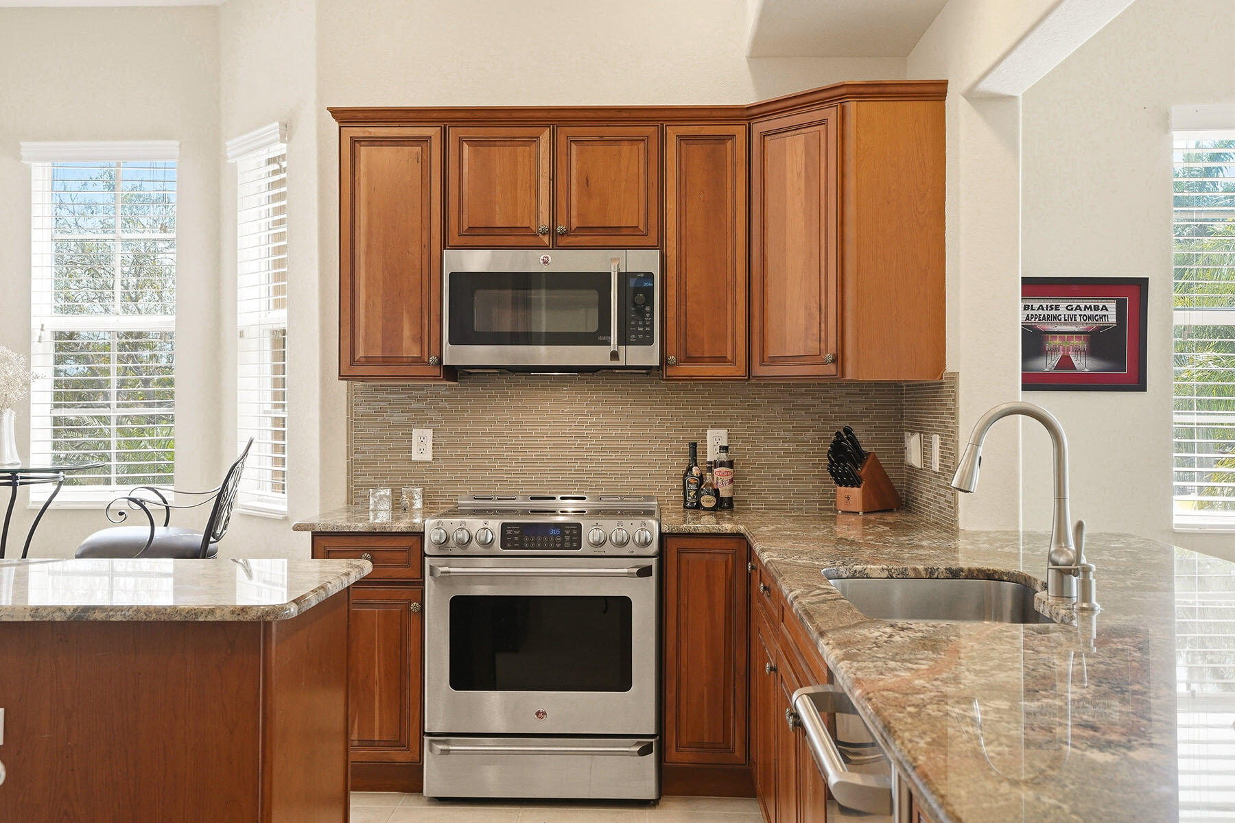 8605 Champions Point, Unit 103 Naples, FL 34113 - Photo 10 of 44 a kitchen with stainless steel appliances granite countertop a sink stove top oven and microwave