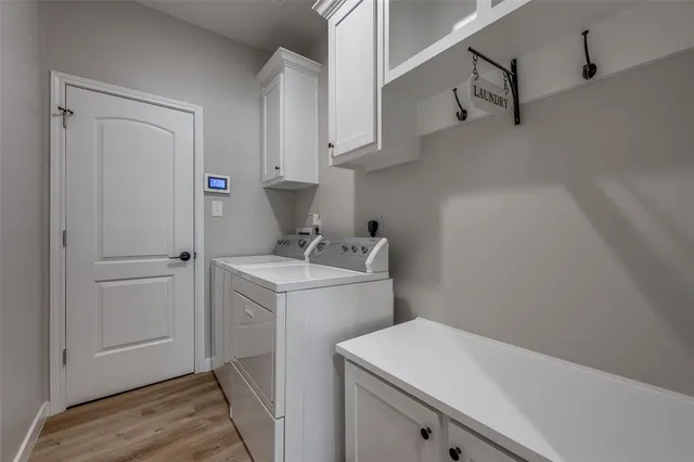 a utility room with cabinets washer and dryer