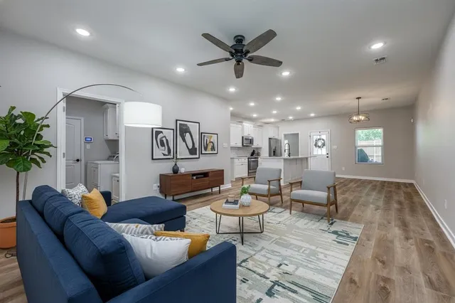 a living room with furniture and a wooden floor
