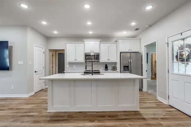 a large kitchen with stainless steel appliances granite countertop a sink a stove a refrigerator and a island