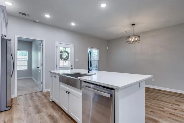 a kitchen with a sink a counter space and wooden floor