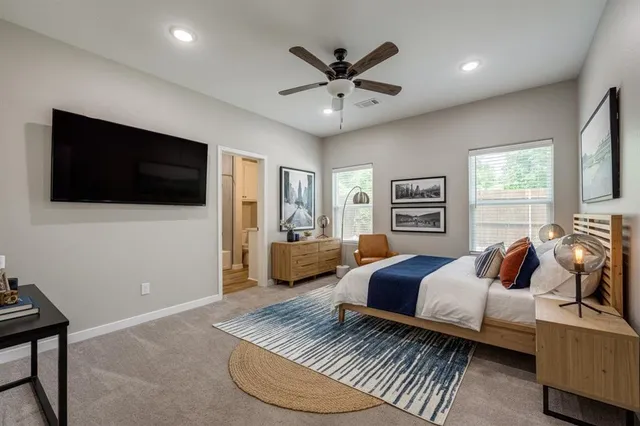 a bedroom with a bed a couch and a flat screen tv