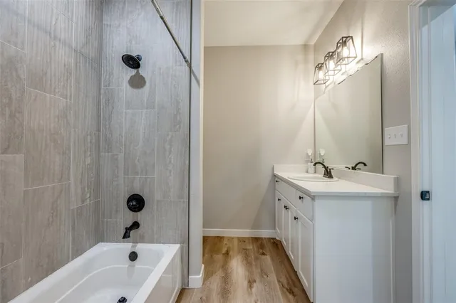 a bathroom with a tub sink and mirror