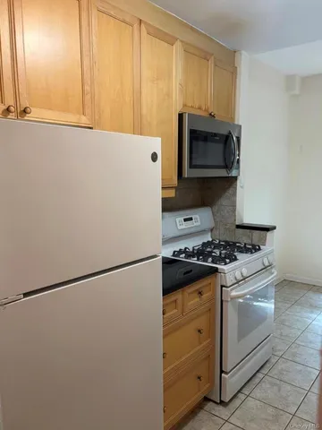 a kitchen with stainless steel appliances white cabinets and a refrigerator