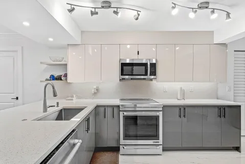 a kitchen with a sink a stove and cabinets
