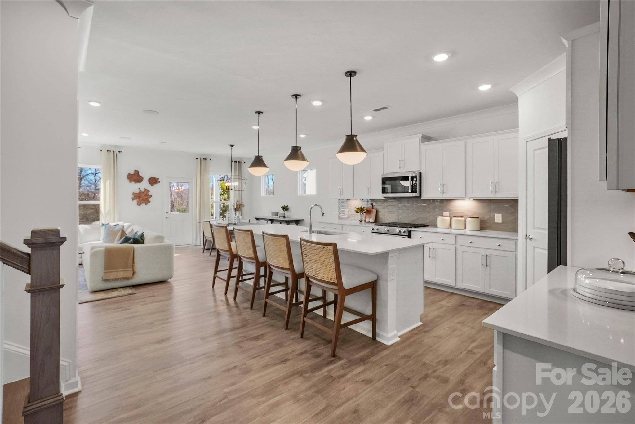 2168 Rone Branch Trail Monroe, NC 28110 - Photo 4 of 22 a kitchen with kitchen island granite countertop a sink cabinets and wooden floor