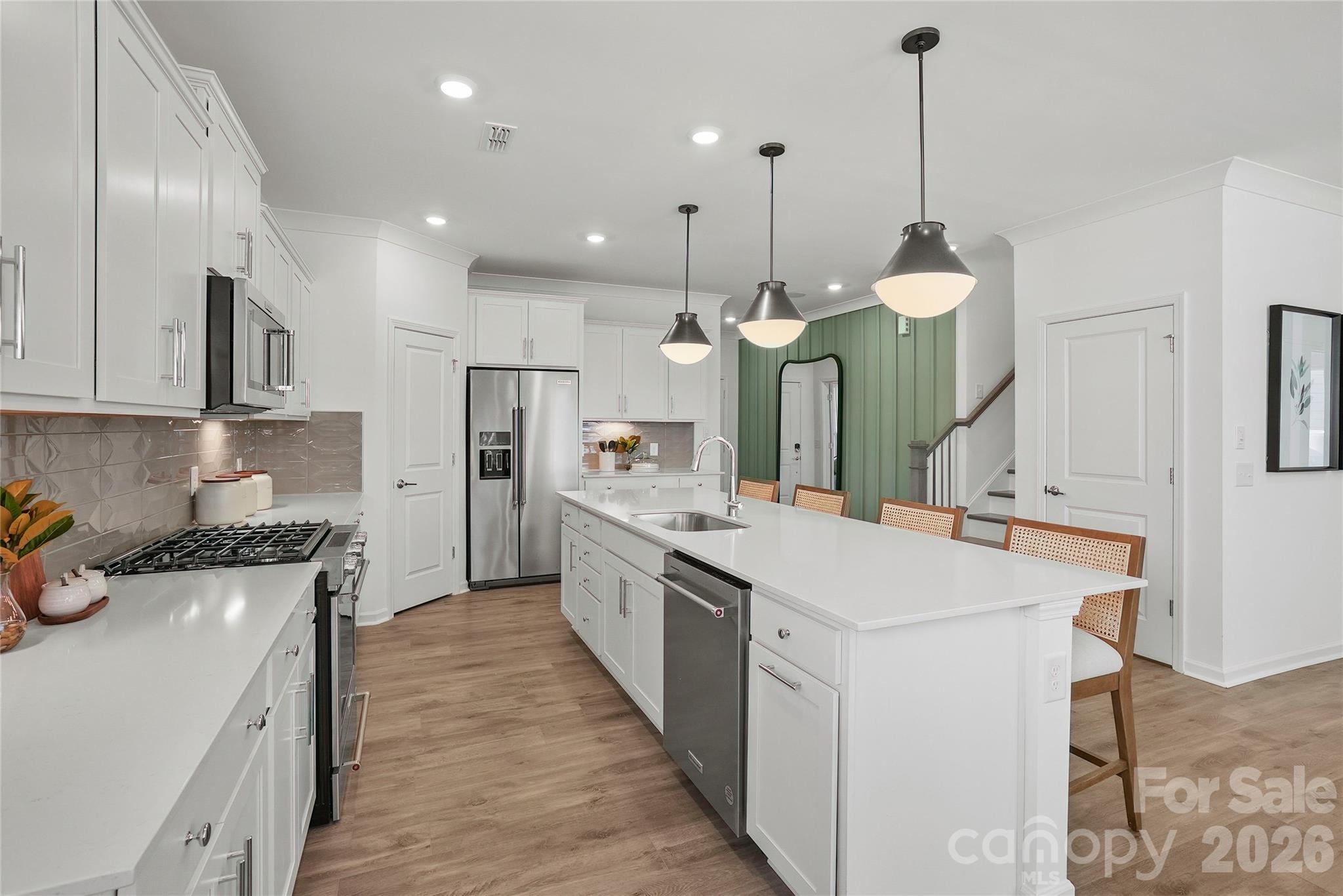 2168 Rone Branch Trail Monroe, NC 28110 - Photo 6 of 22 a kitchen with white cabinets appliances and a chandelier
