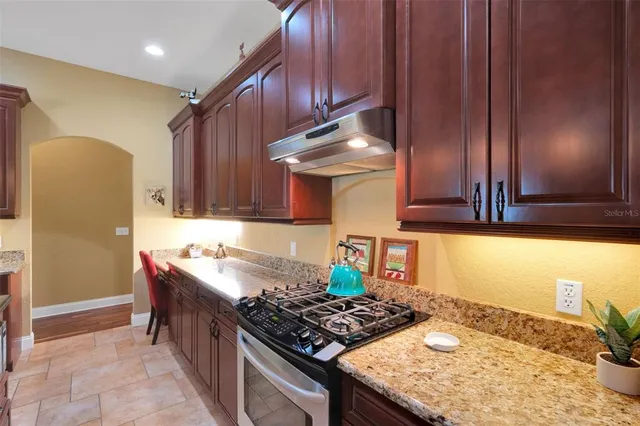 a kitchen with stainless steel appliances granite countertop a stove a sink and a refrigerator