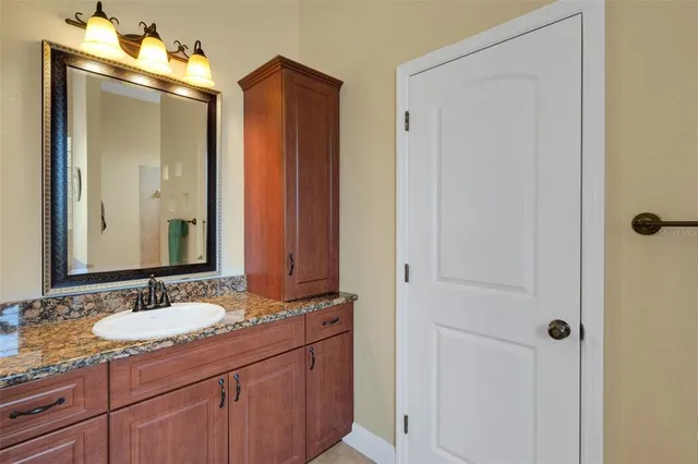 a bathroom with a granite countertop sink and a mirror