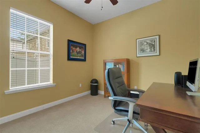 a view of a workspace with furniture and a window