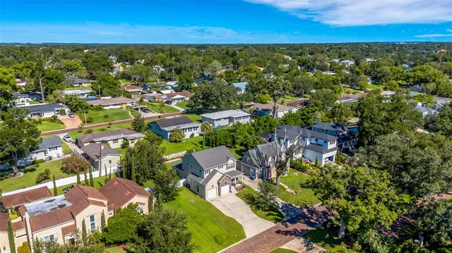 an aerial view of residential houses with outdoor space and trees