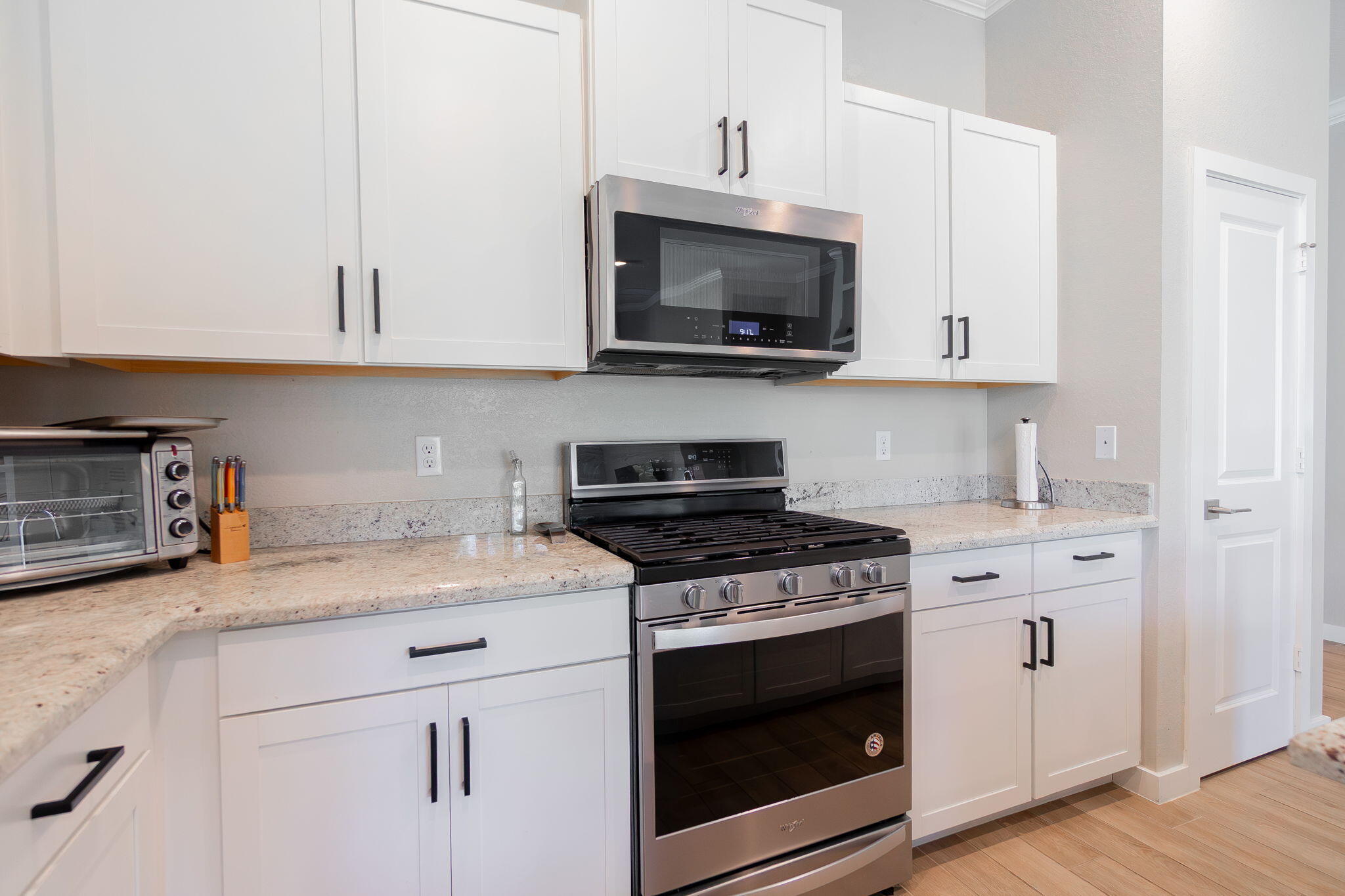 19546 Weathervane Way Loxahatchee, FL 33470 - Photo 18 of 63 a kitchen with granite countertop white cabinets stainless steel appliances and wooden floor