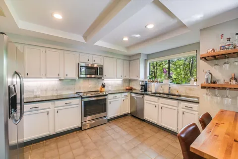 a kitchen with stainless steel appliances granite countertop a sink and cabinets