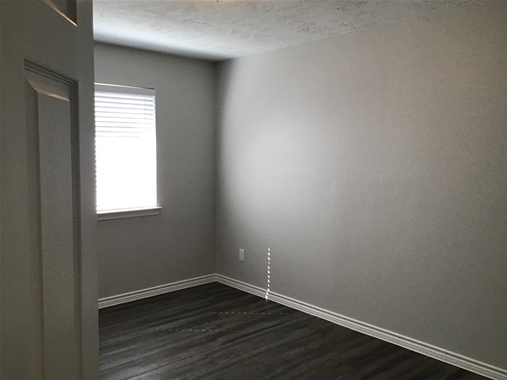 5026 Chase Stone Drive Bacliff, TX 77518 - Photo 12 of 18 a view of an empty room with wooden floor and a window
