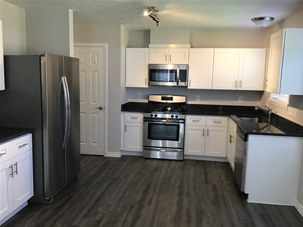5026 Chase Stone Drive Bacliff, TX 77518 - Photo 3 of 18 a kitchen with stainless steel appliances a white cabinets and a wooden floor