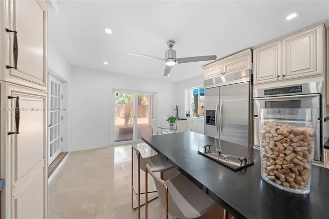 a kitchen with stainless steel appliances kitchen island granite countertop a refrigerator and a sink