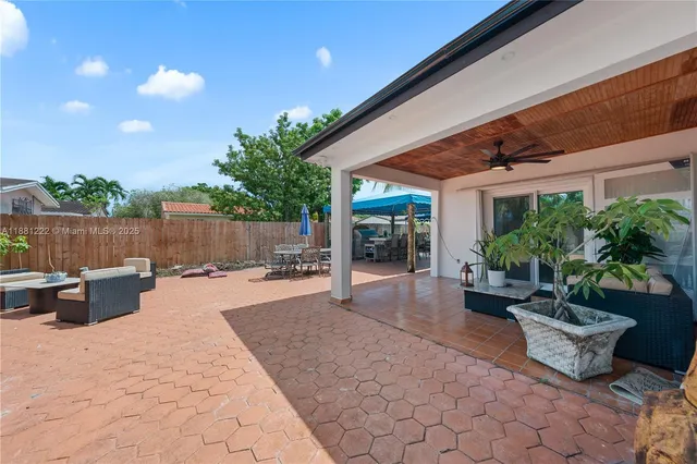 a view of a patio with table and chairs potted plants with wooden fence
