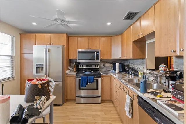 a kitchen with kitchen island granite countertop a refrigerator stove microwave and sink