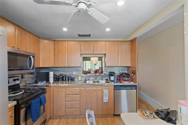 a kitchen with stainless steel appliances kitchen island granite countertop a refrigerator stove sink and cabinets