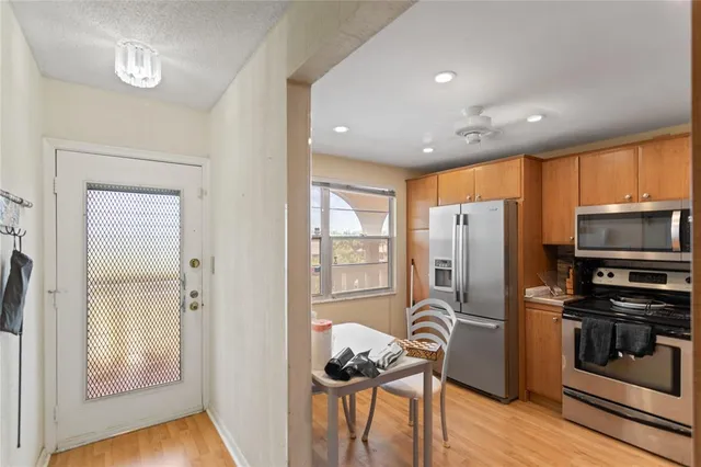 a kitchen with stainless steel appliances granite countertop a refrigerator and a stove top oven