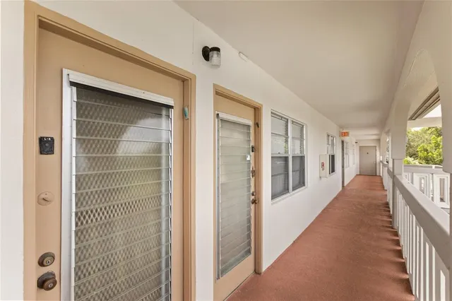 a view of a hallway with wooden floor and windows