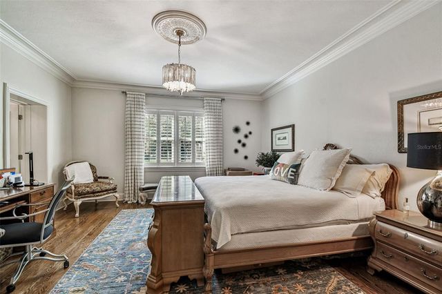 a bedroom with a large bed and a chandelier
