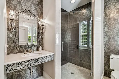 a spacious bathroom with a double vanity sink a toilet a window and a mirror