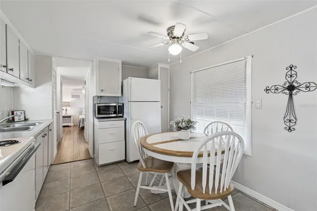 a kitchen with a table chairs refrigerator and cabinets