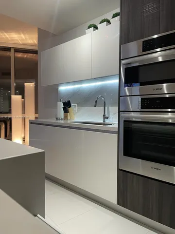 a modern kitchen with a stove and a refrigerator