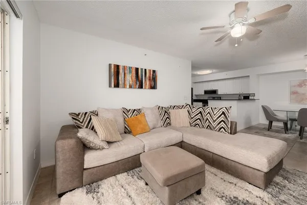a living room with furniture and a ceiling fan