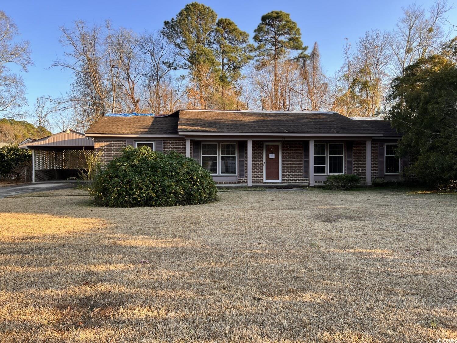 33 Plantation Road Myrtle Beach, SC 29588 - Photo 1 of 22 Ranch-style house featuring a porch, brick siding, a front lawn, and a shingled roof