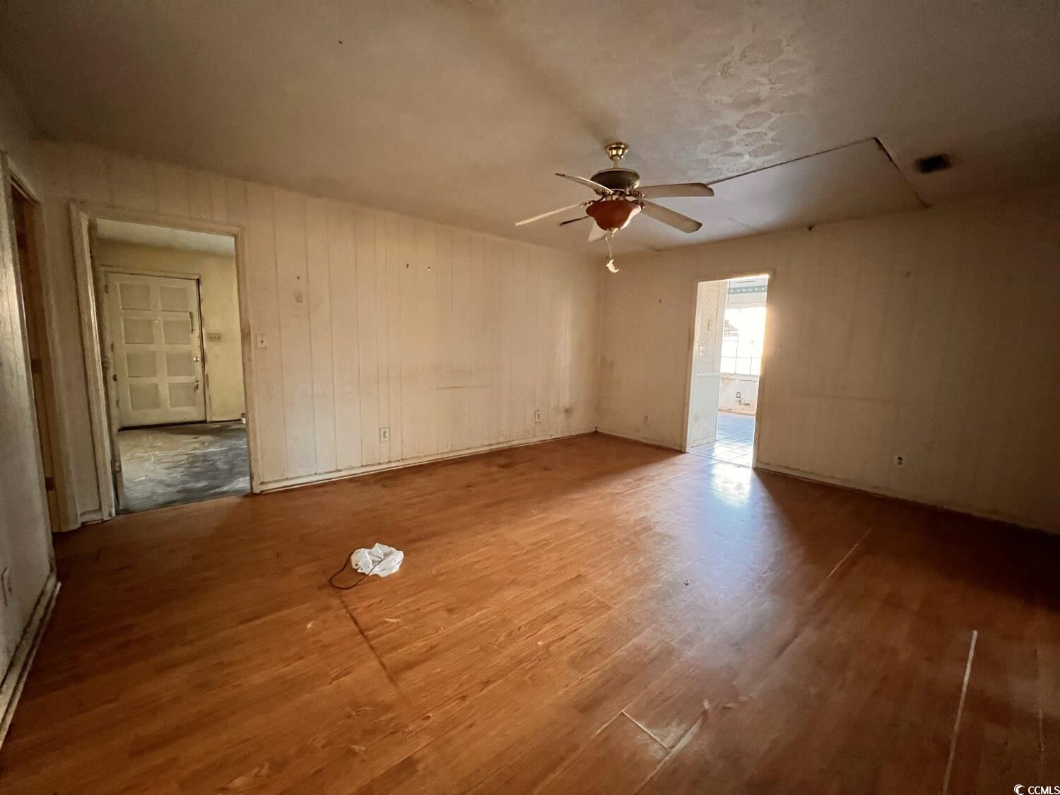 33 Plantation Road Myrtle Beach, SC 29588 - Photo 11 of 22 Spare room with attic access, wood finished floors, a ceiling fan, and wood walls