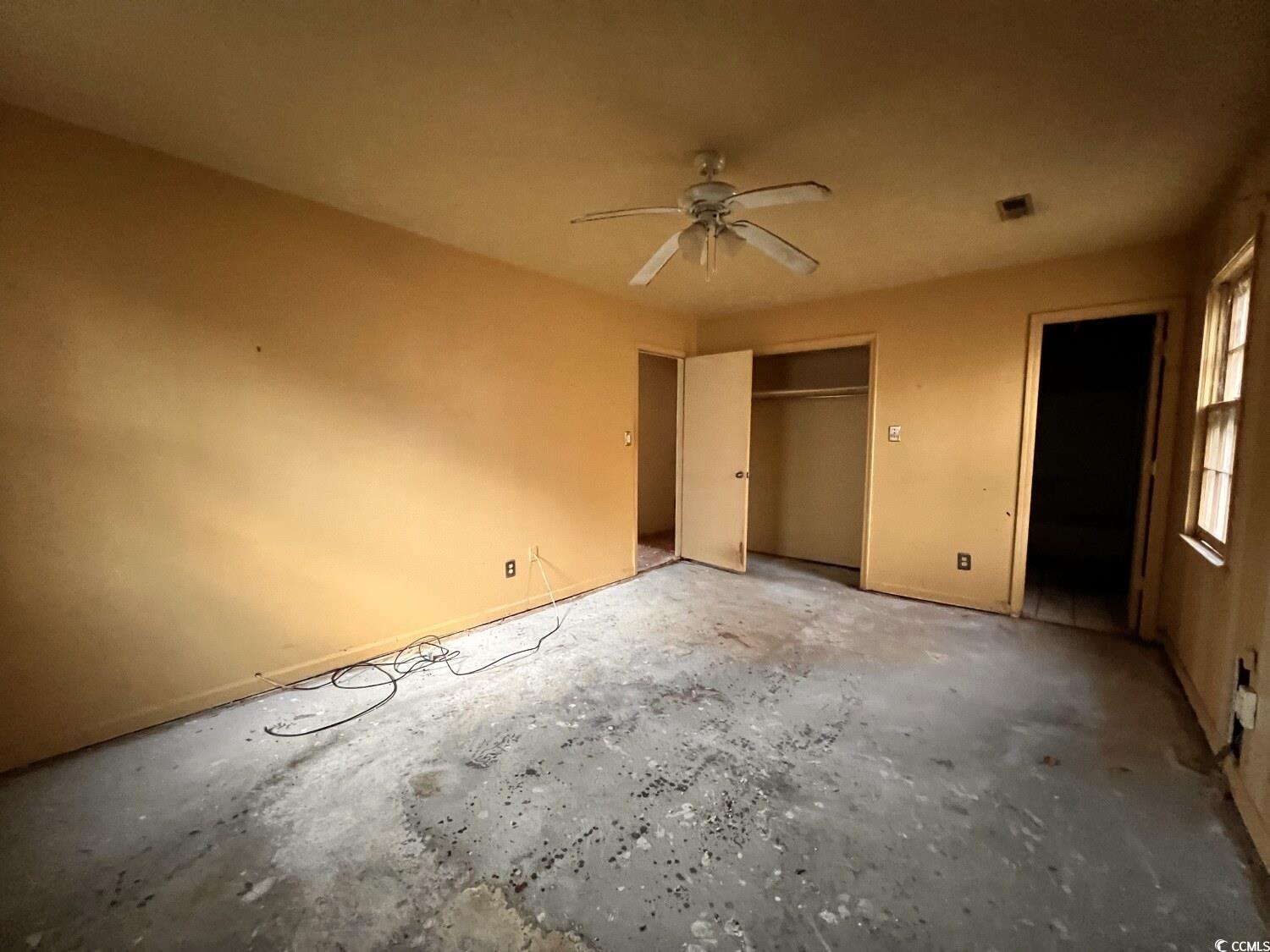 33 Plantation Road Myrtle Beach, SC 29588 - Photo 18 of 22 Unfurnished bedroom featuring a closet, ceiling fan, and concrete flooring