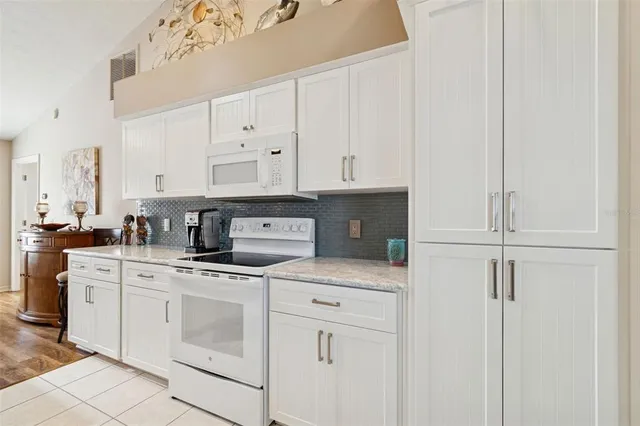 a kitchen with white cabinets and white appliances