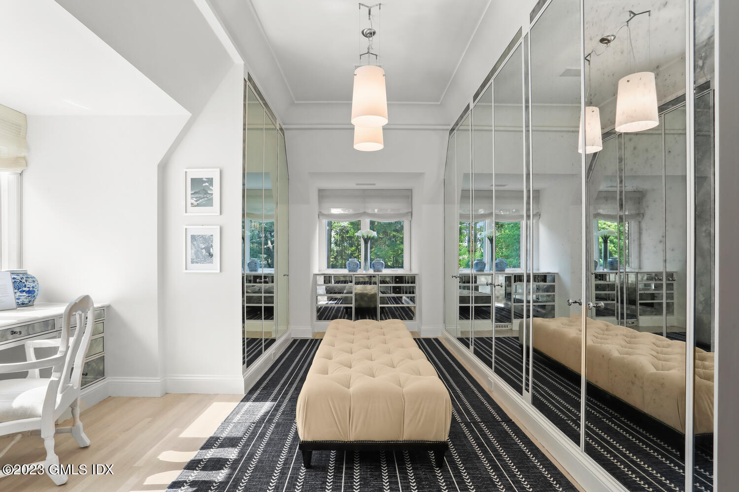 101 Perkins Road Greenwich, CT 06830 - Photo 18 of 41 a dining room with wooden floor a chandelier a wooden table and chairs