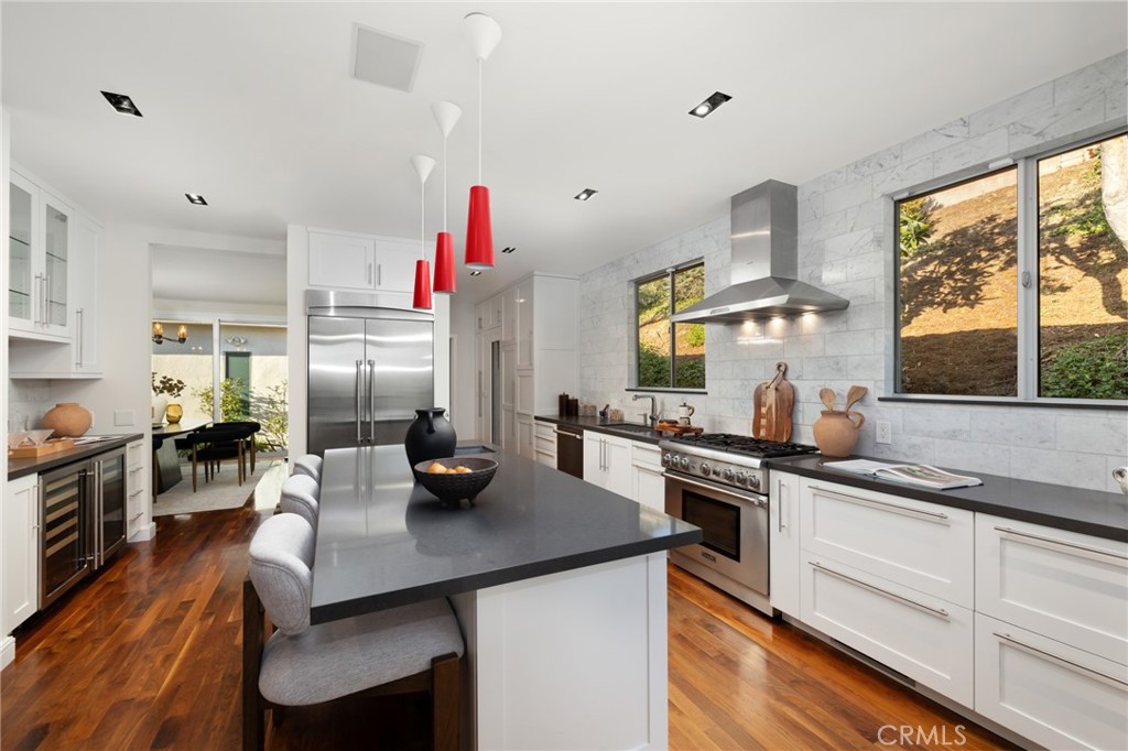 598 Camillo Road Sierra Madre, CA 91024 - Photo 22 of 75 a kitchen with a sink dishwasher a stove and white cabinets with wooden floor