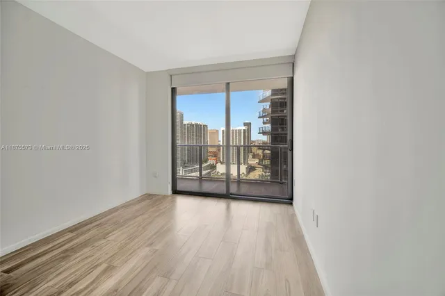 a view of a room with wooden floor and window