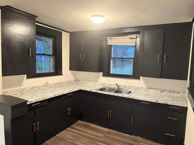 a bathroom with a granite countertop double vanity sink and a mirror