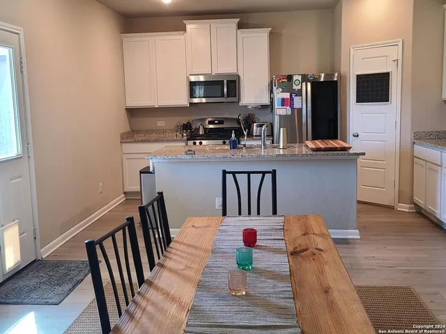 a kitchen with stainless steel appliances kitchen island granite countertop a refrigerator microwave and stove top oven