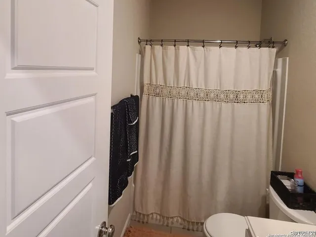 a bathroom with a shower curtain and sink