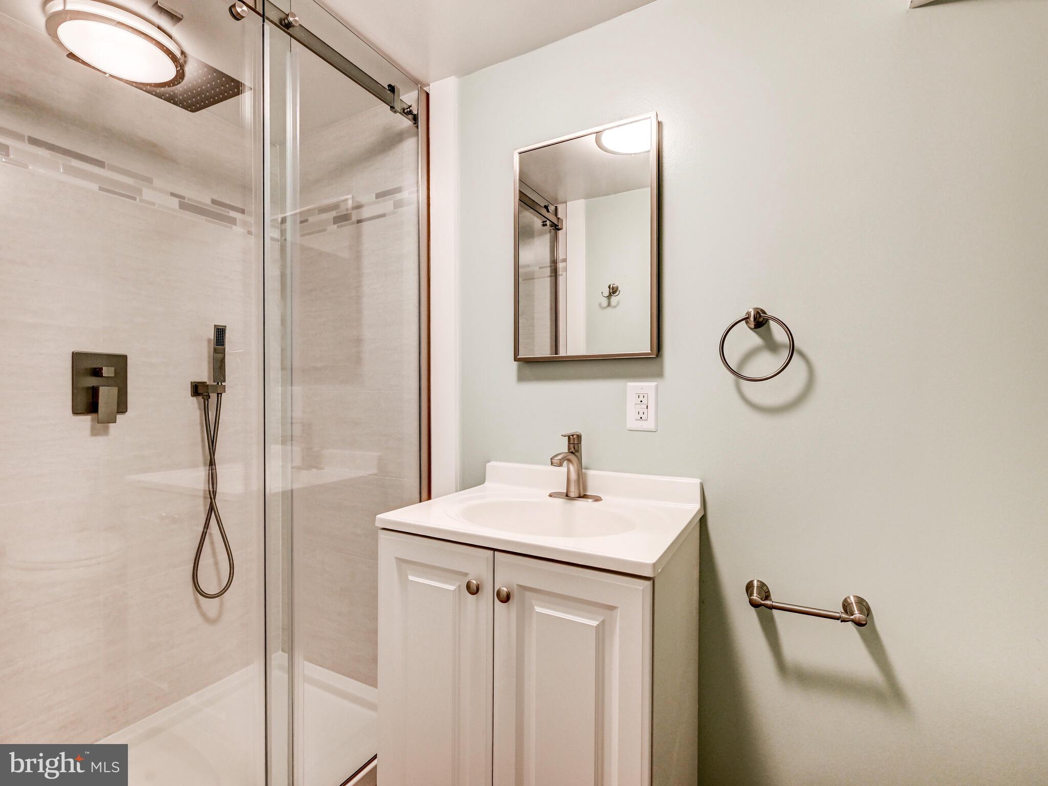 1636 Thetford Road Baltimore, MD 21286 - Photo 30 of 40 a bathroom with a sink mirror and a shower