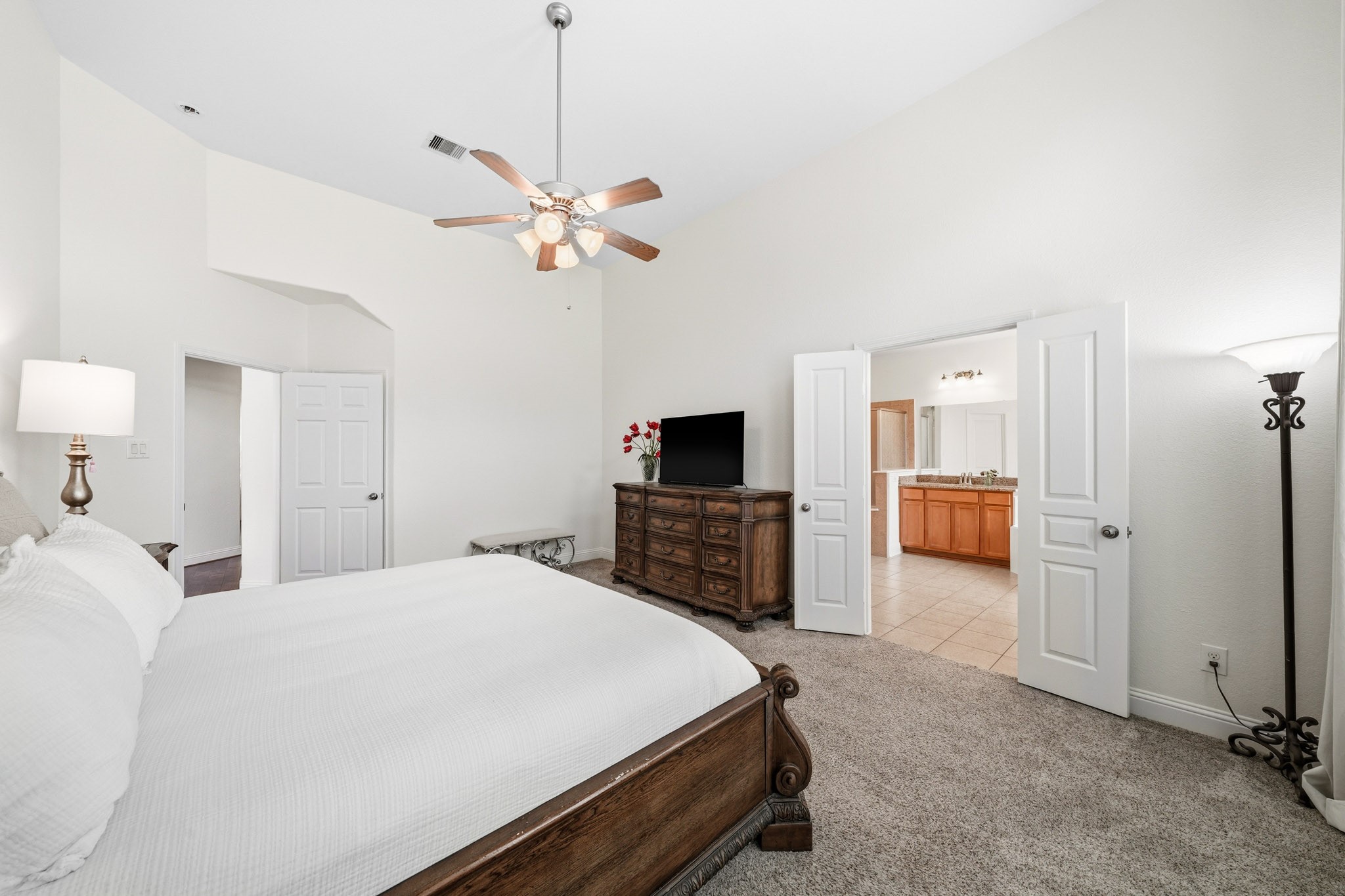 17610 Strackfield Lane Tomball, TX 77377 - Photo 23 of 50 Another view of the primary suite showcased the double-door entry to the primary bath and the ceiling fan with integrated lights create a serene retreat tailored to your comfort at any hour.