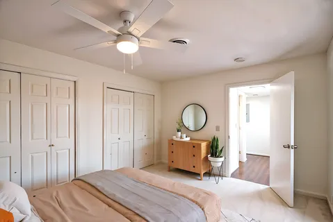 a bedroom with a bed a mirror and a chandelier