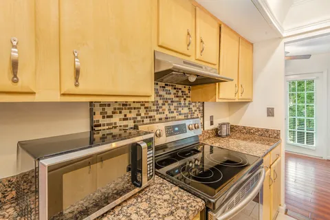 a kitchen with stainless steel appliances granite countertop a stove a sink and a microwave