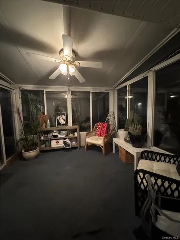 a living room with furniture a flat screen tv and a ceiling fan