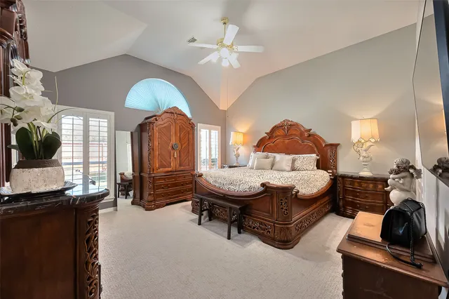 a bedroom with a bed a chandelier and dresser