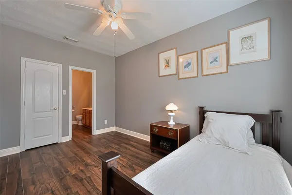 a bedroom with bed and wooden floor